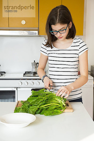 Mädchen hackt Gemüse in der Küche
