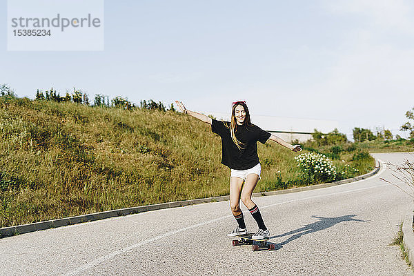 Spanien  glückliche Teenagerin auf Skateboard