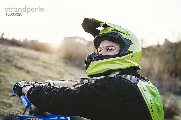 Porträt eines Motocross-Fahrers bei Sonnenuntergang