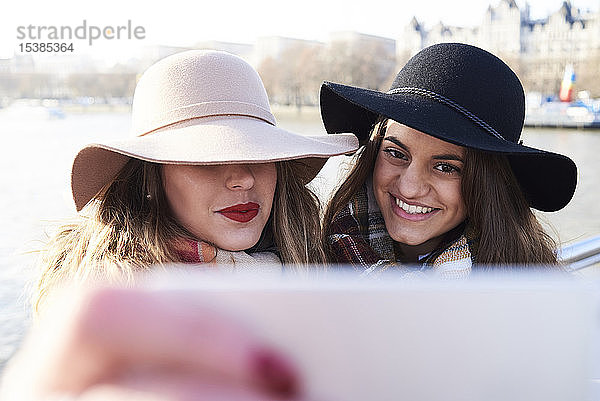 UK  London  zwei Frauen mit Schlapphüten bei einem Selfie auf der Millennium Bridge