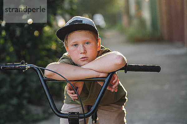 Porträt eines Jungen mit bmx-Fahrrad auf der Strasse