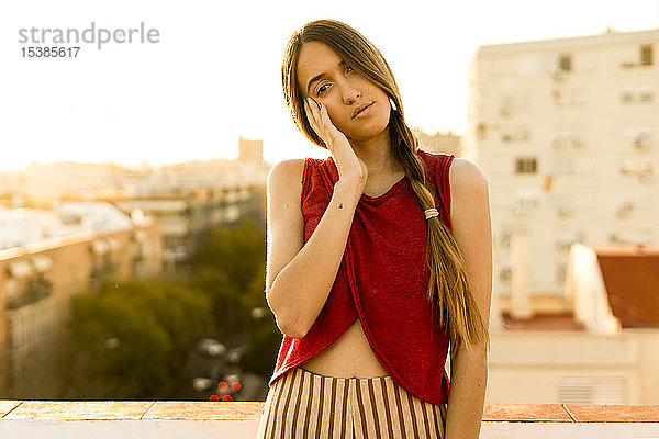 Porträt einer Teenagerin auf der Dachterrasse der Stadt bei Sonnenuntergang