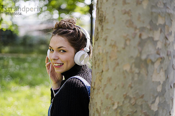 Junge Frau mit Kopfhörern in einem Park