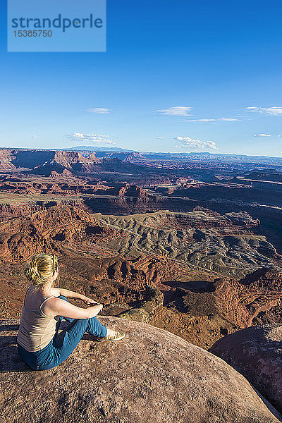 USA  Utah  Frau an einem Aussichtspunkt vom Dead Horse State Park aus über die Canyonlands und den Colorado River