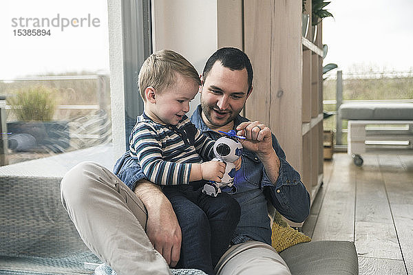 Vater und Sohn spielen zu Hause mit einem Spielzeugroboter