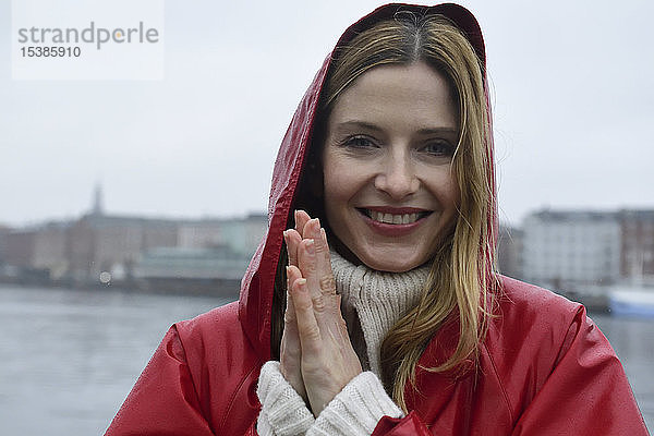 Dänemark  Kopenhagen  Porträt einer glücklichen Frau an der Uferpromenade bei Regenwetter