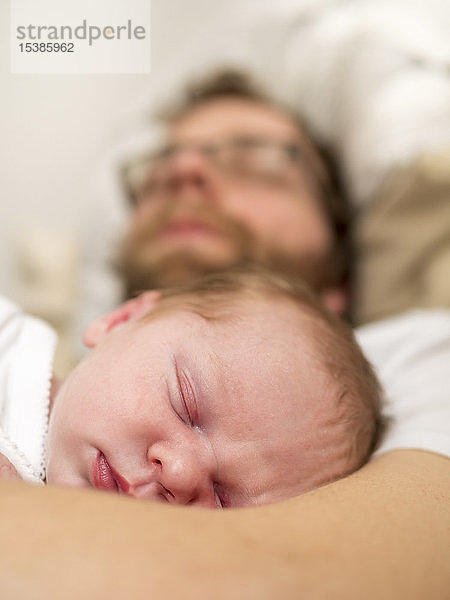 Vater und neugeborenes Mädchen schlafen