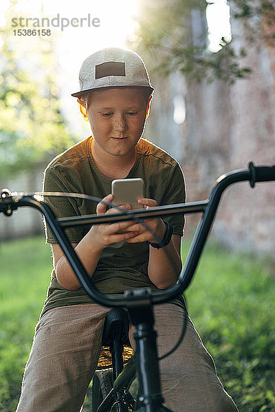 Junge mit bmx-Fahrrad mit Handy