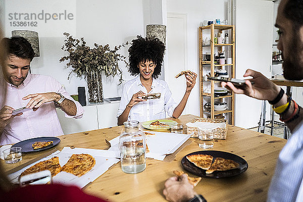 Freunde haben Spaß  essen Pizza  machen Smartphone-Fotos