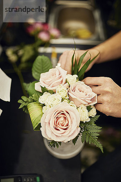 Nahaufnahme eines Floristen beim Arrangieren von Blumen im Blumengeschäft