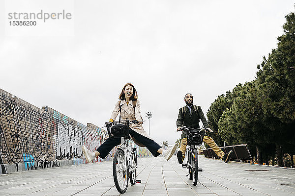 Sorgenfreies Paar fährt E-Bike auf einer Promenade