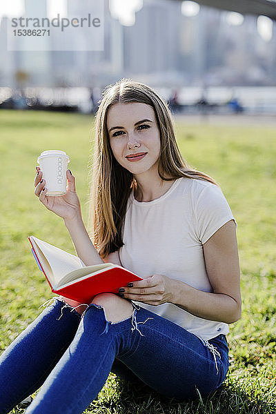 Junge Frau erkundet New York City  macht eine Pause  liest ein Buch
