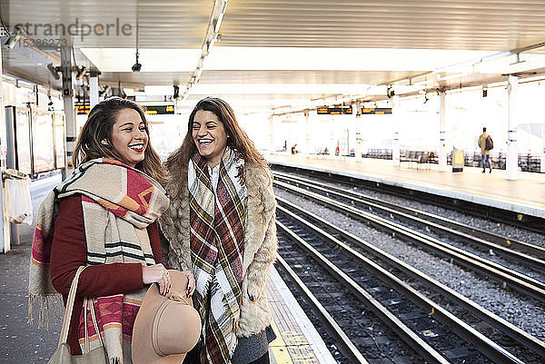 UK  London  zwei glückliche Frauen am U-Bahn-Bahnsteig