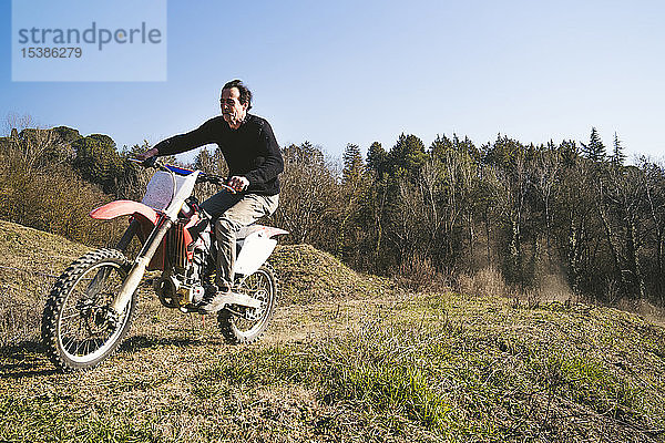 Älterer Motocross-Fahrer auf der Rennstrecke