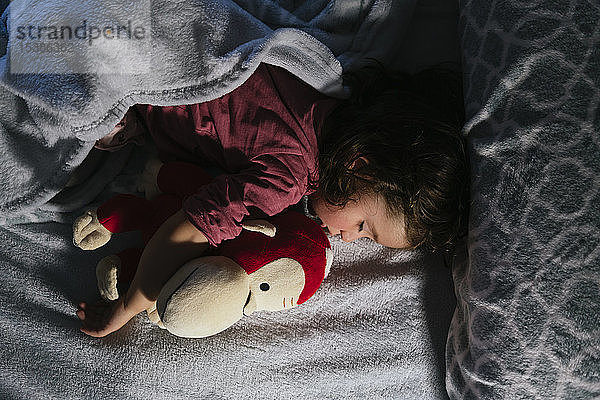 Kleinkind Mädchen schläft im Bett mit einem Plüschhund Orang-Utan