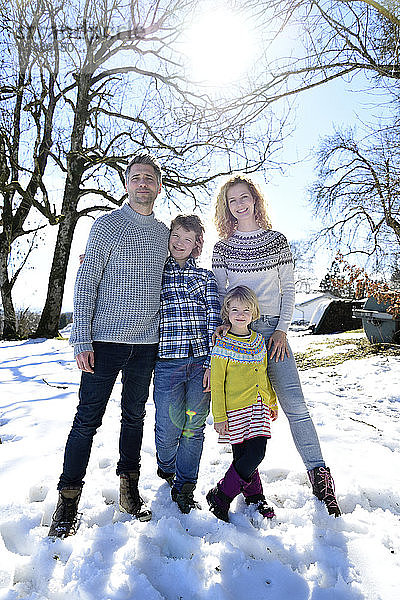 Porträt einer glücklichen Familie auf einem Feld im Winter
