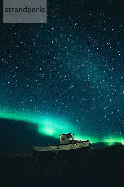 Norwegen  Lofoten  Eggum  Fischerboot unter Sternenhimmel und Nordlichtern