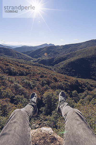 Spanien  Navarra  Wald von Irati  Männerbeine baumeln über der Waldlandschaft im Gegenlicht