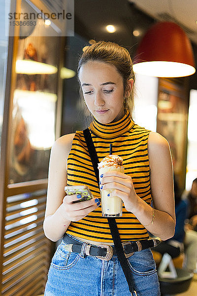 Spanien  Teenager-Mädchen mit Milchshakes per Smartphone