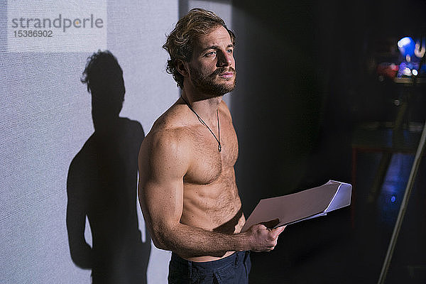 Porträt eines Schauspielers ohne Hemd mit Drehbuchproben im Theater
