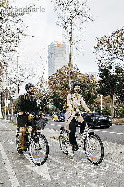 Ein Paar fährt in der Stadt auf dem Fahrradweg E-Bikes