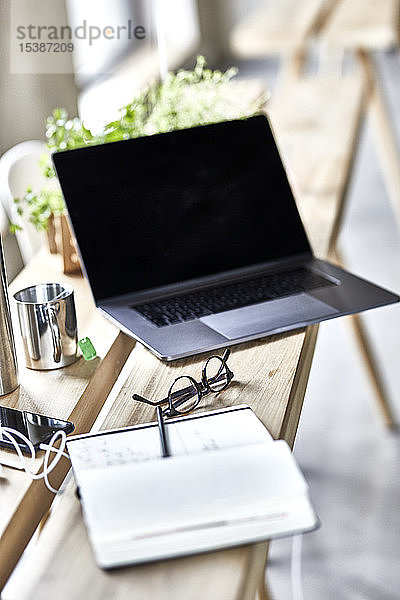 Notebook und Laptop auf Holzbrettern im Büro