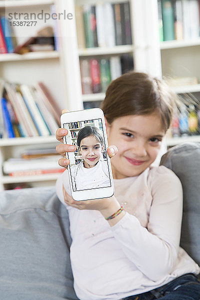 Lächelndes Mädchen zeigt Selbstliebe auf Handy-Display