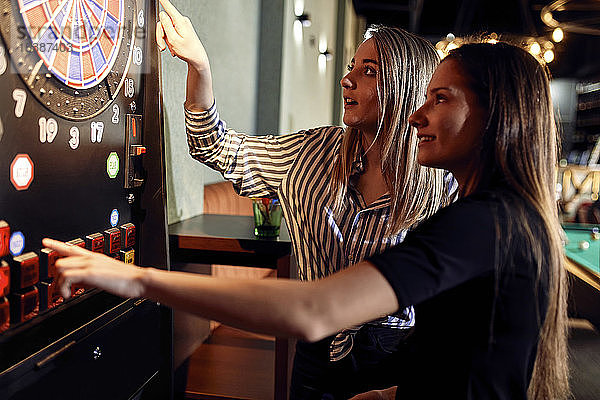 Zwei Frauen beim Dartspiel mit elektronischer Dartscheibe