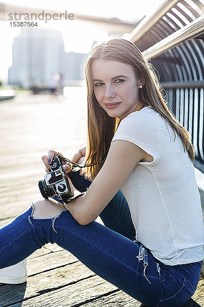 Junge Frau erkundet New York City und fotografiert an der Brooklyn Bridge