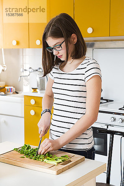 Mädchen hackt Gemüse in der Küche
