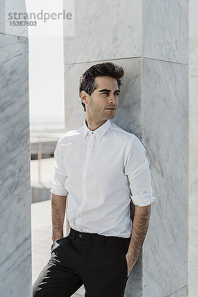 Porträt eines modischen Mannes mit weißem Hemd und schwarzer Hose