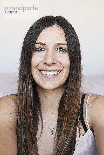 Porträt einer glücklichen jungen Frau mit langen braunen Haaren