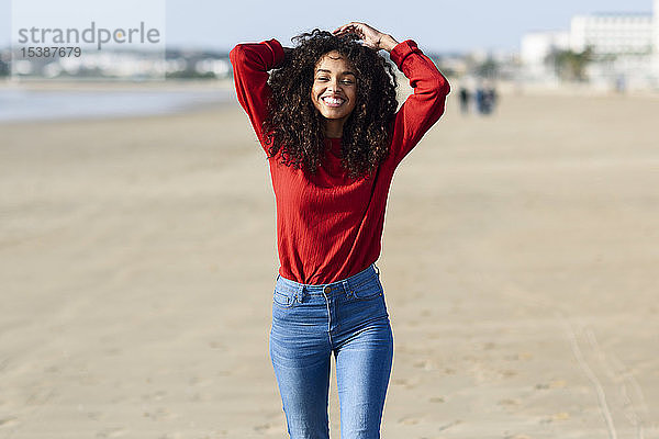 Porträt einer glücklichen jungen Frau am Strand