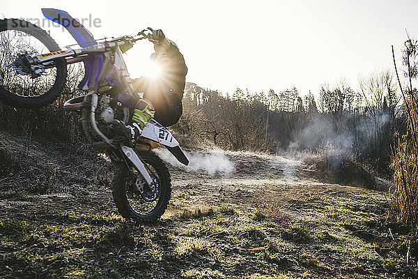 Motocross-Fahrer mit einem Wheelie auf der Rennstrecke