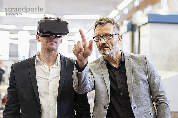 Zwei Geschäftsleute mit VR-Brillen in der Fabrik