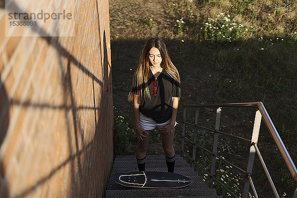 Spanien  Teenagerin mit Skateboard auf der Treppe