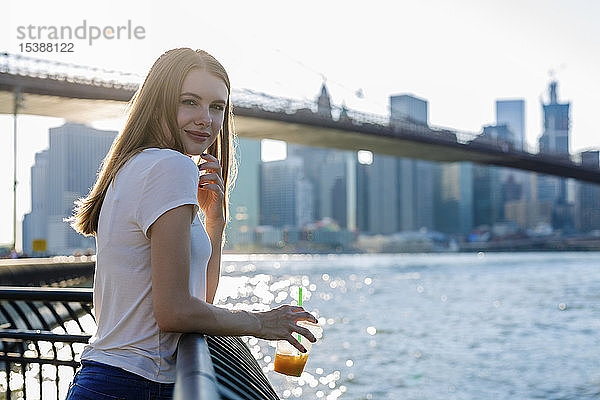 Junge Frau erkundet New York City mit Blick auf die Brooklyn Bridge