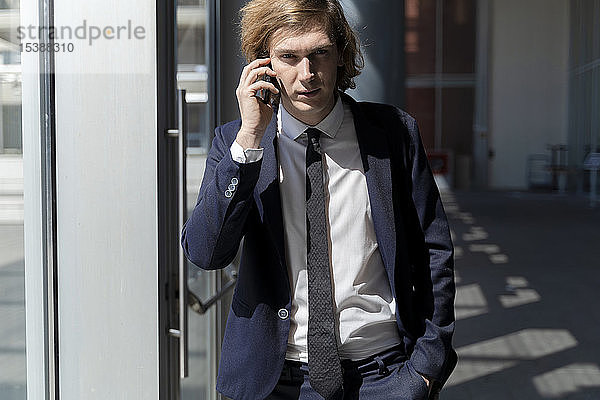Italien  Florenz  junger Geschäftsmann auf Smartphone im Freien