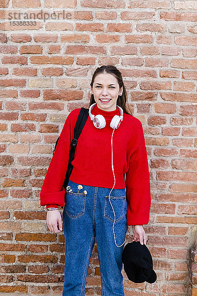 Junge Frau mit rotem Pullover und Kopfhörern in Verona