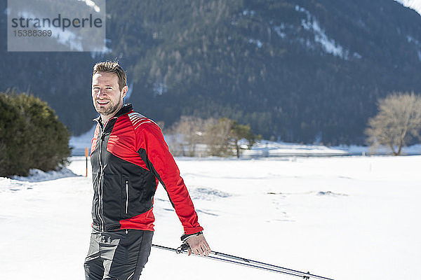 Österreich  Tirol  Achensee  Porträt eines lächelnden Mannes beim Skilanglauf