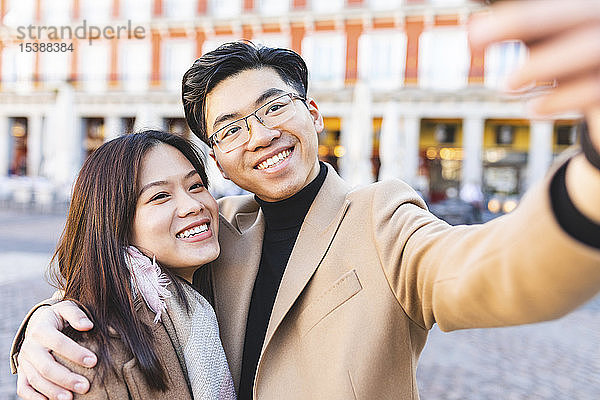 Spanien  Madrid  glückliches junges Paar  das sich in der Stadt ein Selfie gönnt