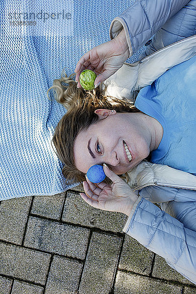 Frau am Boden liegend   Auge mit Osterei bedeckt