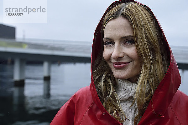 Dänemark  Kopenhagen  Porträt einer lächelnden Frau an der Uferpromenade bei Regenwetter
