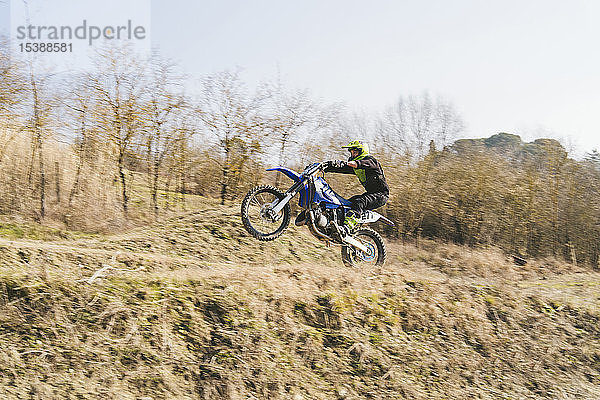 Motocross-Fahrer mit einem Wheelie auf der Rennstrecke