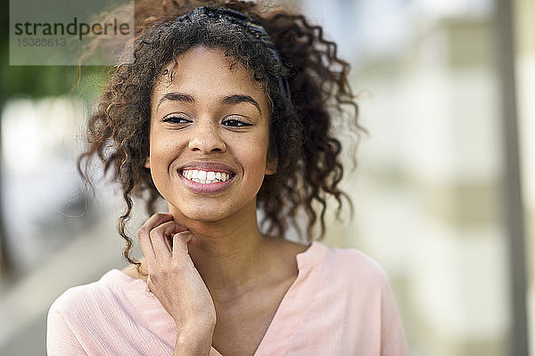 Porträt einer lächelnden jungen Frau in der Stadt