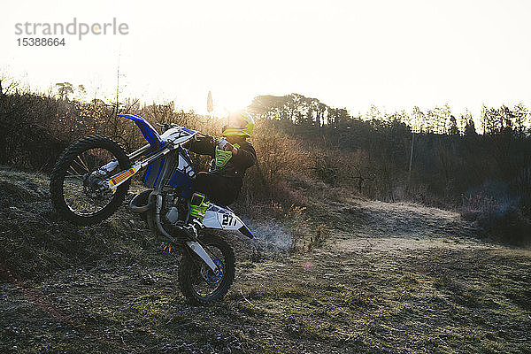 Motocross-Fahrer mit einem Wheelie auf der Rennstrecke