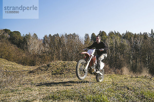 Älterer Motocross-Fahrer auf der Rennstrecke