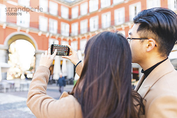 Spanien  Madrid  junges Paar beim Fotografieren mit einem Smartphone in der Stadt
