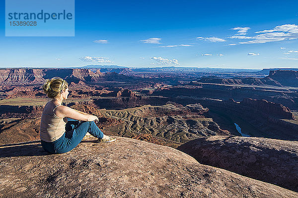 USA  Utah  Frau an einem Aussichtspunkt vom Dead Horse State Park aus über die Canyonlands und den Colorado River