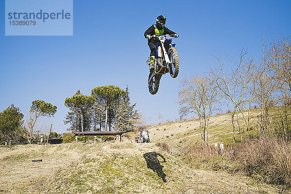 Motocross-Fahrer springt auf der Rennstrecke